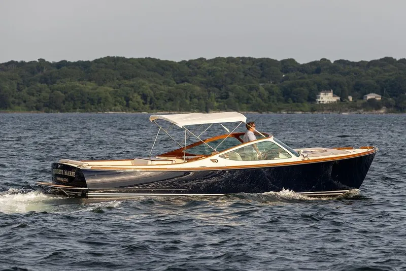 Slide: The Image of 2008 Hinckley Talaria 29R cruising on water with scenic forest backdrop. - 28