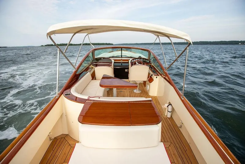 Slide: The Image of 2008 Hinckley Talaria 29R luxury boat interior with elegant wood finish and ocean backdrop. - 13