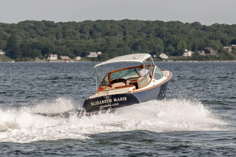 Slide: The Image of 2008 Hinckley Talaria 29R cruising on water with scenic shoreline backdrop. - 40
