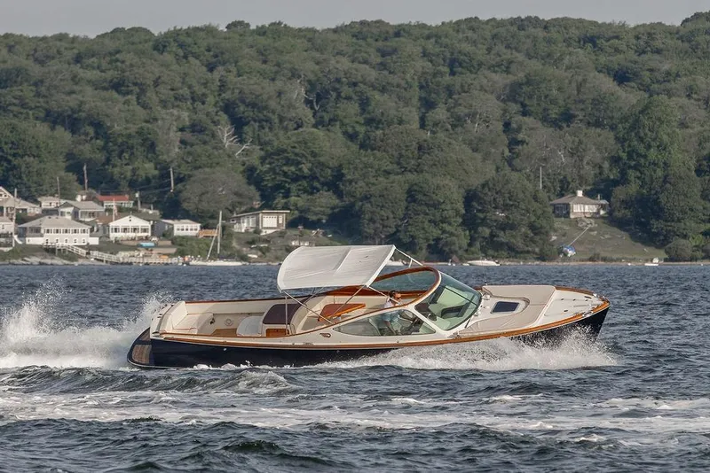 Slide: The Image of 2008 Hinckley Talaria 29R cruising on a scenic lake with lush green shoreline. - 41