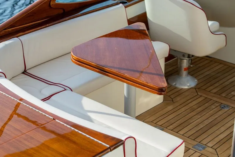 Slide: The Image of Luxurious interior of 2008 Hinckley Talaria 29R with wooden table and white seating. - 17