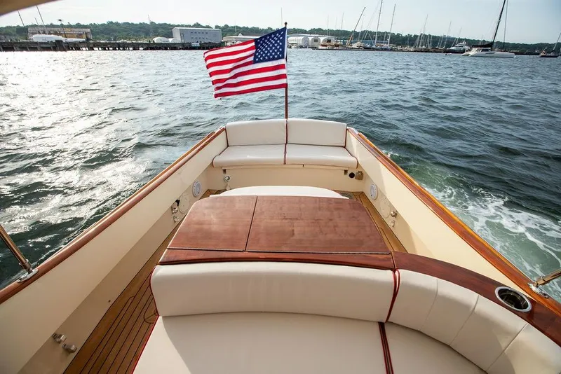 Slide: The Image of 2008 Hinckley Talaria 29R boat with American flag on open water. - 4