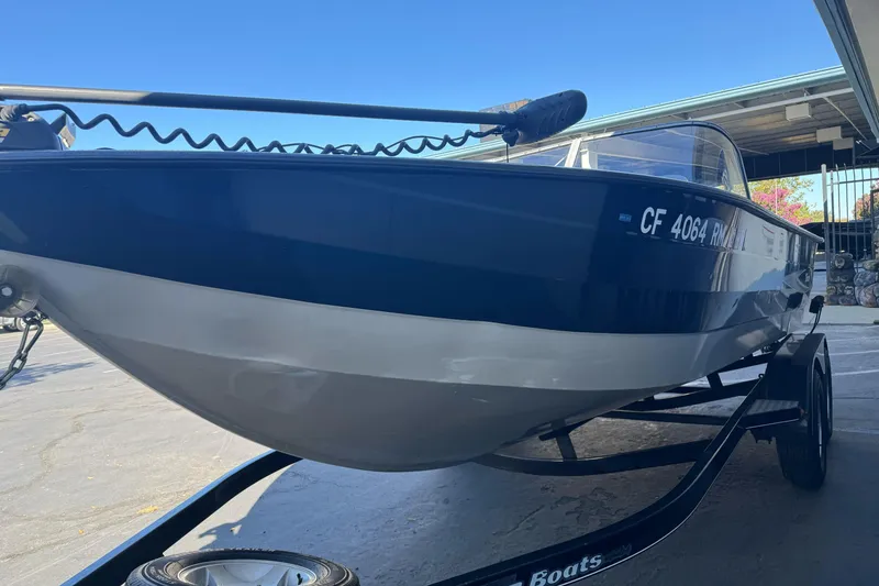 Slide: The Image of 2005 Triton DV 186 Mag boat on trailer, blue and white hull, parked outdoors. - 7