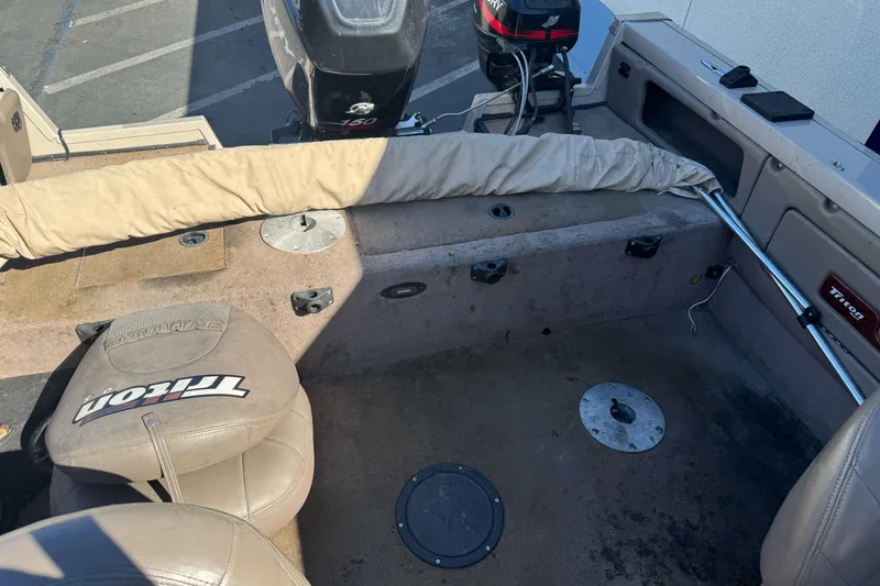 Slide: The Image of 2005 Triton DV 186 Mag boat interior with seating and motor, showcasing fishing setup. - 14