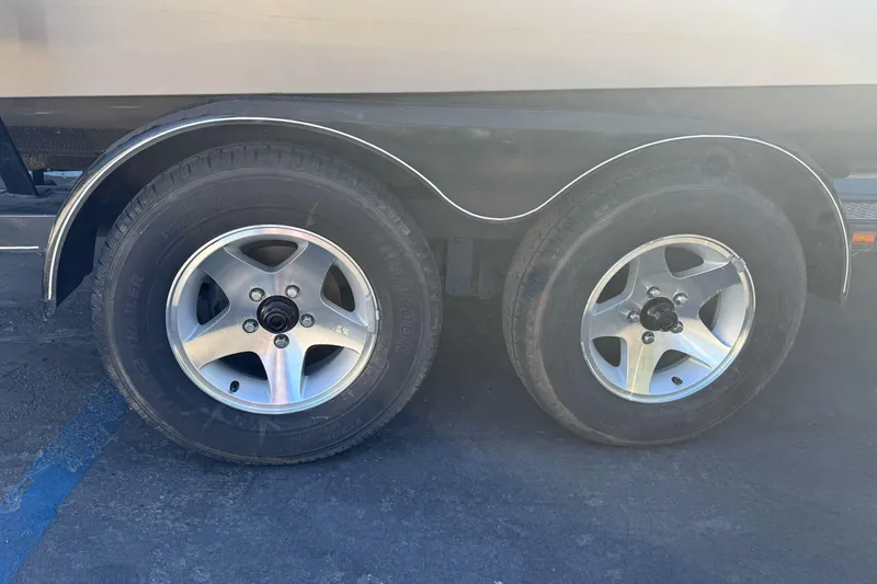 Slide: The Image of Trailer wheels of a 2005 Triton DV 186 Mag boat on pavement. - 4