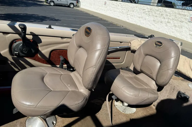 Slide: The Image of 2005 Triton DV 186 Mag boat interior with two beige seats in a parking lot. - 15