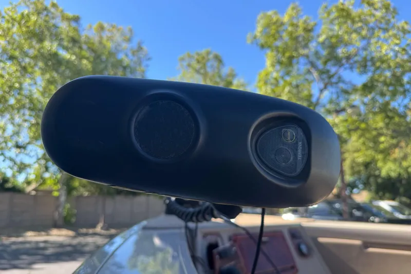 Slide: The Image of Close-up of a 2005 Triton DV 186 Mag boat component against a sunny, tree-filled background. - 8