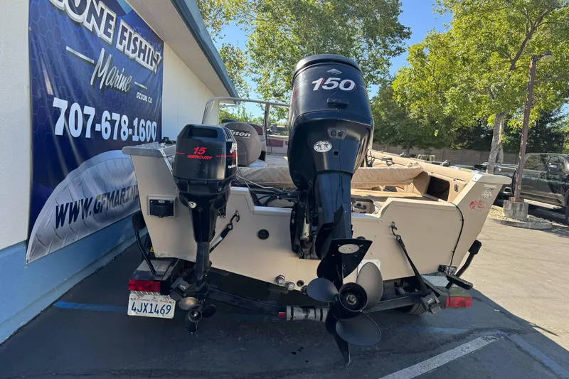 Slide: The Image of 2005 Triton DV 186 Mag boat with dual outboard motors parked outdoors. - 2