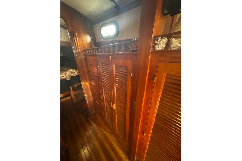 Slide: The Image of Interior of 1977 Tayana 37 Cutter, featuring wooden cabinetry and cozy nautical design. - 26