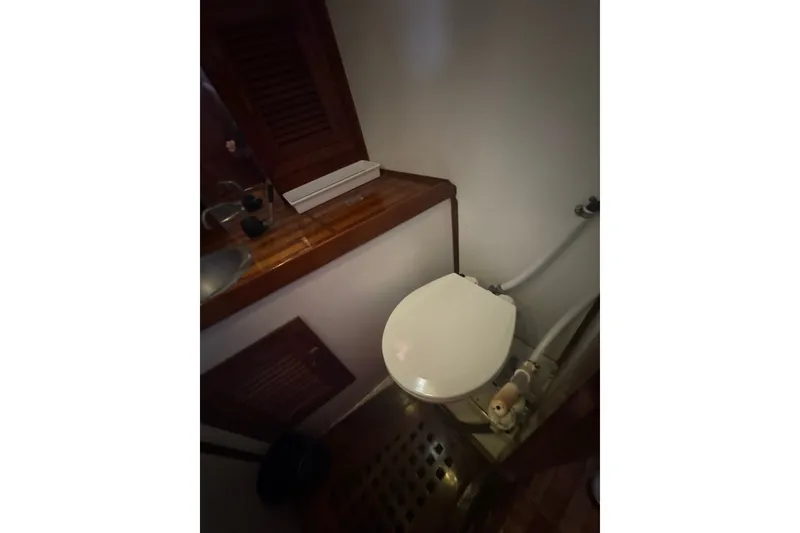Slide: The Image of 1977 Tayana 37 Cutter yacht bathroom with wooden accents and compact toilet. - 25