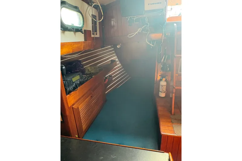 Slide: The Image of Interior of 1977 Tayana 37 Cutter sailboat with wooden cabinetry and nautical equipment. - 9