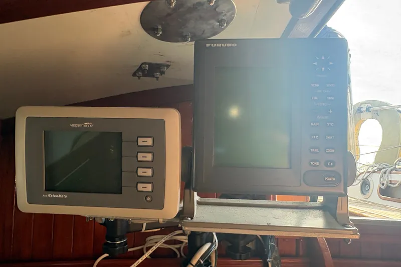 Slide: The Image of Navigation equipment on a 1977 Tayana 37 Cutter sailboat, featuring Vesper Marine and Furuno displays. - 12