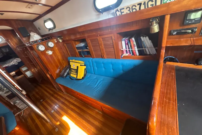 Slide: The Image of Interior of 1977 Tayana 37 Cutter sailboat with wooden finish and blue seating. - 22