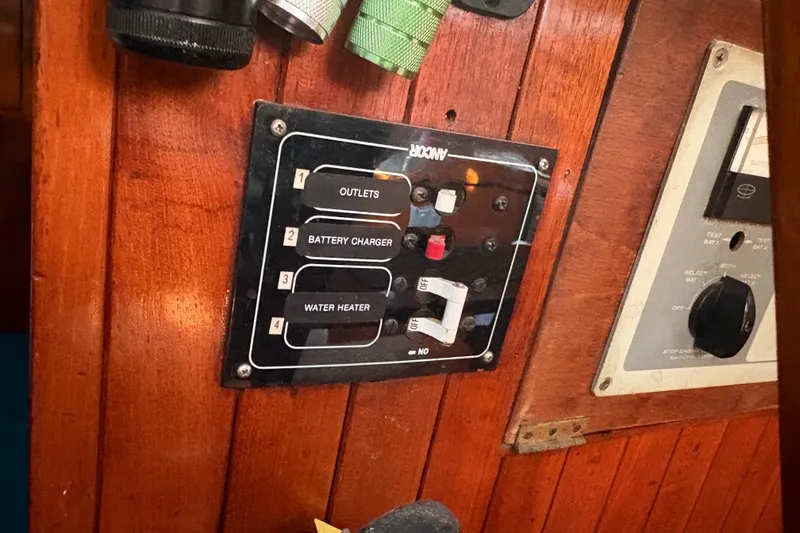 Slide: The Image of Electrical panel on a 1977 Tayana 37 Cutter sailboat, featuring outlets and switches. - 5