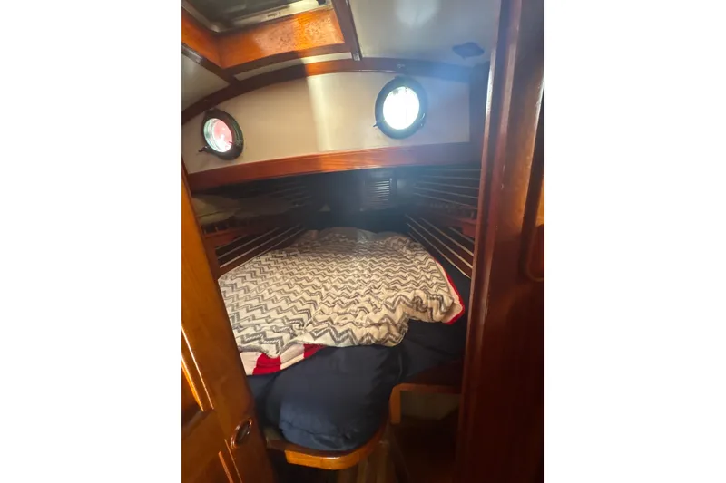Slide: The Image of Cozy cabin interior of 1977 Tayana 37 Cutter sailboat with portholes and patterned bedding. - 23