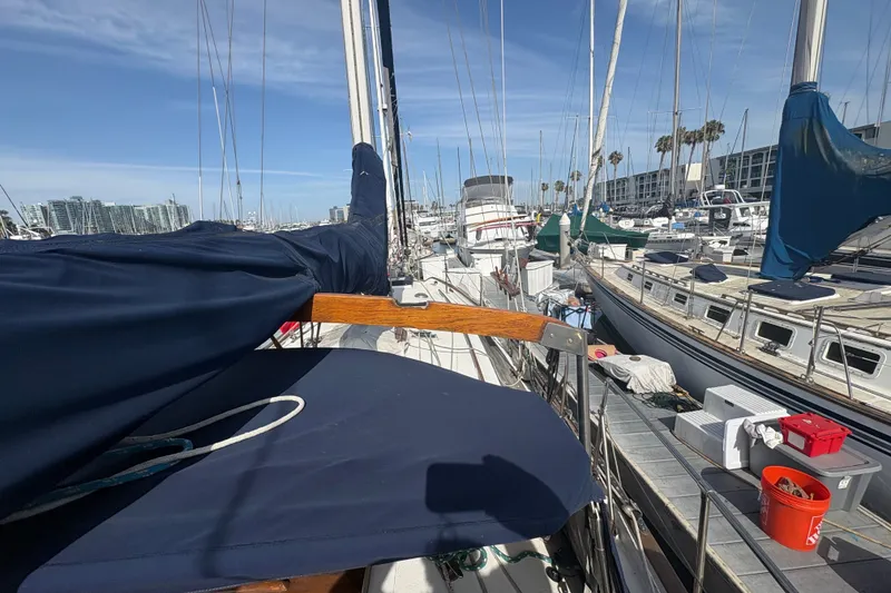 Slide: The Image of 1977 Tayana 37 Cutter sailboat docked in a marina, surrounded by other boats. - 14
