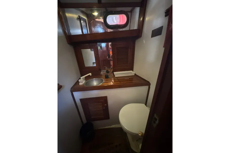 Slide: The Image of 1977 Tayana 37 Cutter yacht bathroom with wooden cabinetry and compact sink. - 24