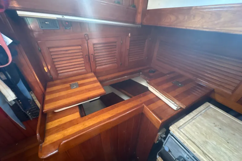 Slide: The Image of 1977 Tayana 37 Cutter interior with wooden cabinetry and foldable table. - 21