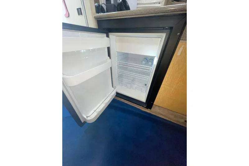 Slide: The Image of Open refrigerator inside 1999 Formula 31 Performance Cruiser, showcasing interior storage space. - 34