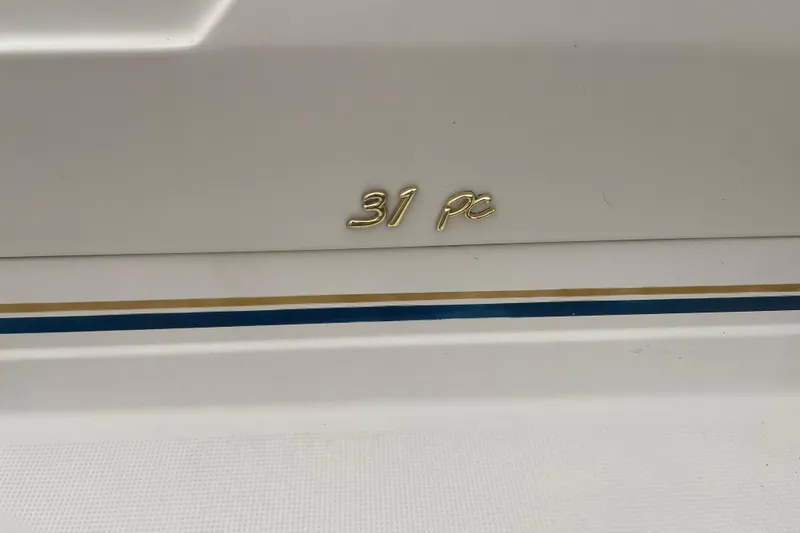 Slide: The Image of 1999 Formula 31 Performance Cruiser emblem on white hull with blue and gold stripes. - 2
