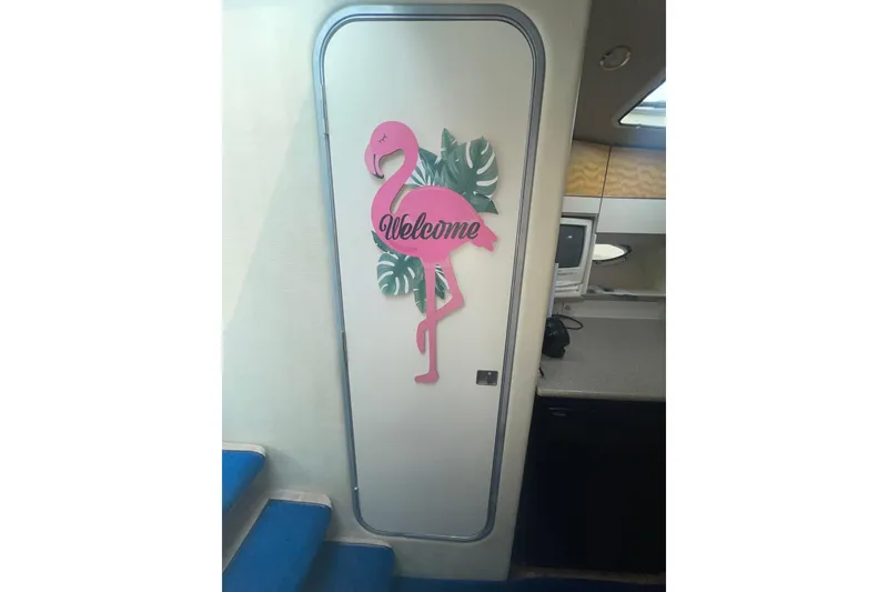 Slide: The Image of Pink flamingo welcome sign on a 1999 Formula 31 Performance Cruiser cabin door. - 33