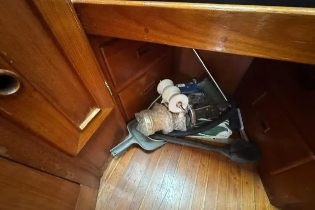 Slide: The Image of Wooden interior of a 1977 Kelly Peterson 44 sailboat with cleaning supplies. - 38
