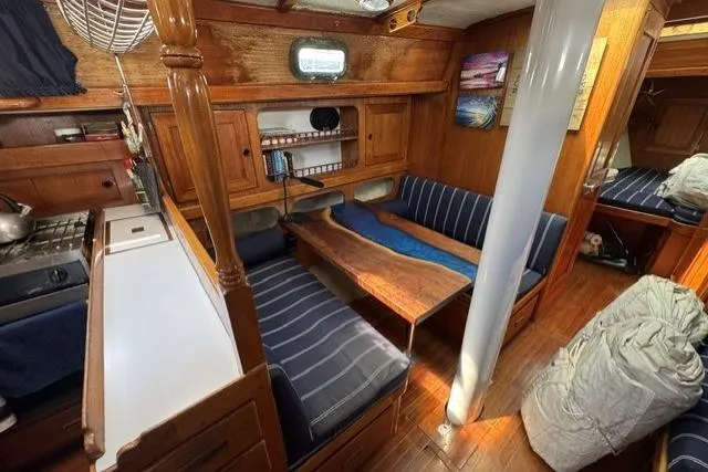 Slide: The Image of Interior of a 1977 Kelly Peterson 44 sailboat with wooden furnishings and blue-striped seating. - 12