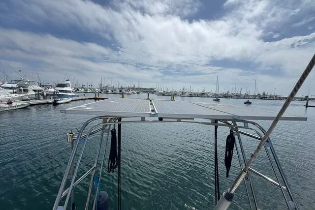 Slide: The Image of Sailboat with solar panels docked in a marina, Kelly Peterson 44, 1977 model. - 37