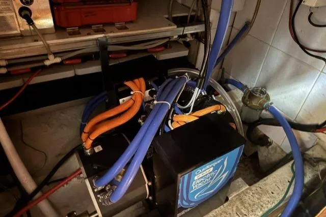 Slide: The Image of Engine room of a 1977 Kelly Peterson 44 sailboat with colorful wiring and equipment. - 24