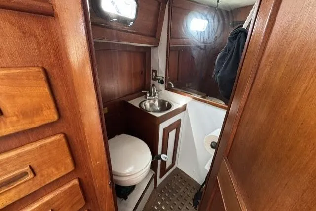 Slide: The Image of 1977 Kelly Peterson 44 yacht bathroom with wooden cabinetry and compact sink. - 23