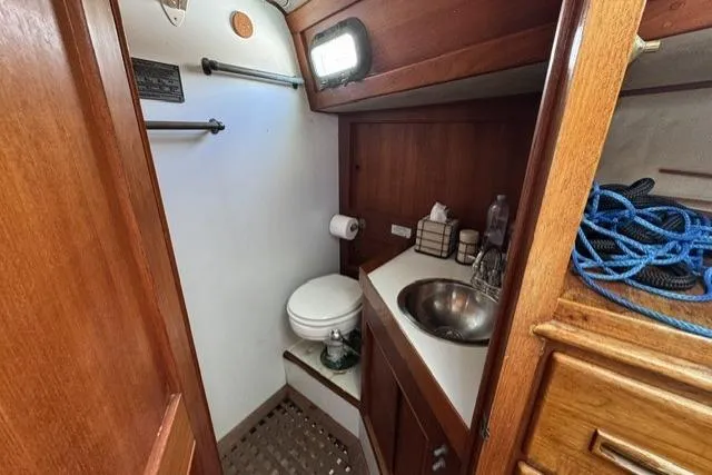 Slide: The Image of 1977 Kelly Peterson 44 yacht bathroom with wooden cabinetry, sink, and toilet. - 15