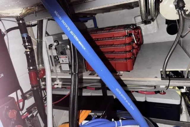Slide: The Image of Engine room of a 1977 Kelly Peterson 44 sailboat with visible wiring and equipment. - 25