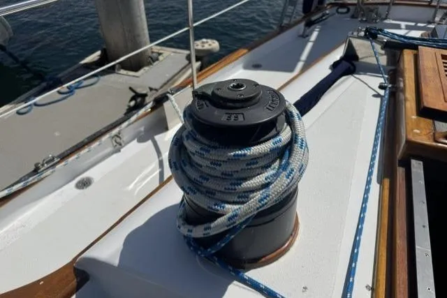 Slide: The Image of Winch with rope on 1977 Kelly Peterson 44 sailboat deck, docked by the water. - 4