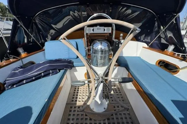 Slide: The Image of 1976 Kelly Peterson 44 sailboat cockpit with blue cushions and wooden steering wheel. - 35