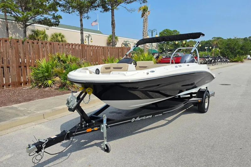 Slide: The Image of 2022 Hurricane SunDeck Sport 185 OB boat on trailer, parked on a sunny street. - 16