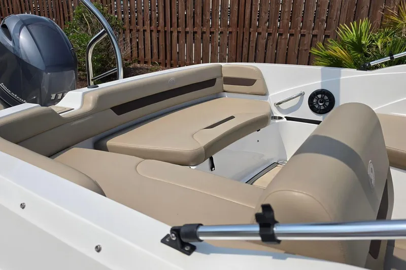 Slide: The Image of 2022 Hurricane SunDeck Sport 185 OB boat interior with beige seating and outboard motor. - 6