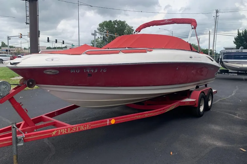 Slide: The Image of 2003 Monterey 228SI Montura Bowrider on red trailer, parked outdoors under cloudy sky. - 7