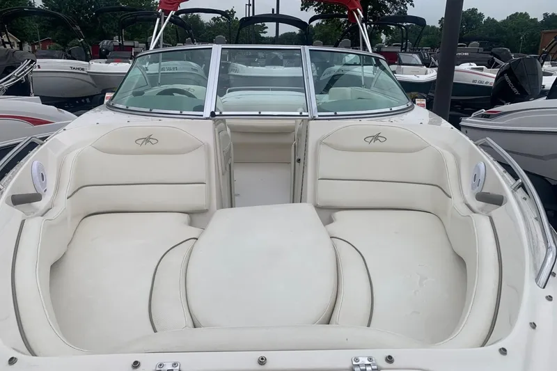 Slide: The Image of 2003 Monterey 228SI Montura Bowrider with white seating, docked among other boats. - 4
