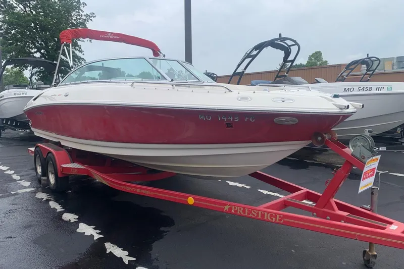 Slide: The Image of 2003 Monterey 228SI Montura Bowrider on red trailer, parked outdoors. - 2