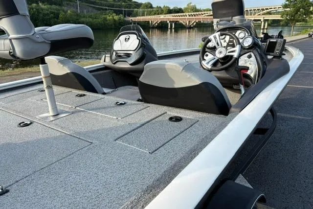 Slide: The Image of 2018 Tracker Pro Team 195 TXW boat, featuring sleek design and modern controls, docked by a river. - 23