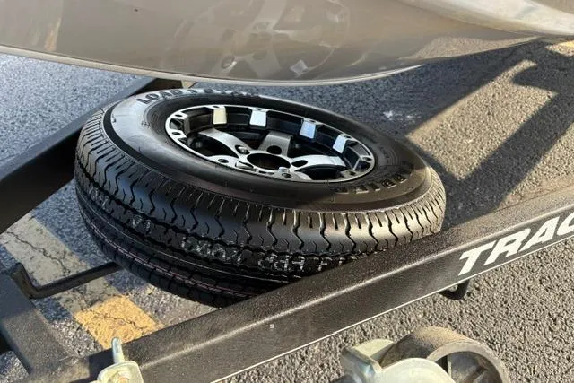 Slide: The Image of 2018 Tracker Pro Team 195 TXW trailer tire on asphalt, showcasing wheel detail. - 55