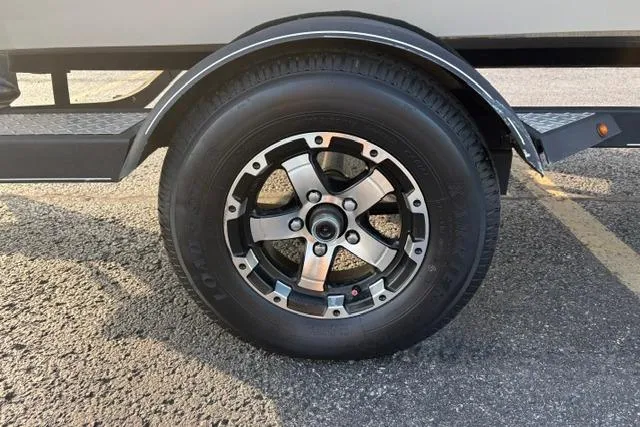 Slide: The Image of 2018 Tracker Pro Team 195 TXW 40th Anniversary Edition trailer wheel on asphalt. - 53