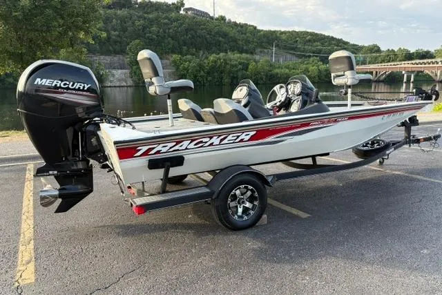 Slide: The Image of 2018 Tracker Pro Team 195 TXW boat with Mercury engine, parked near a scenic river. - 7