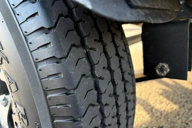 Slide: The Image of Close-up of a tire on a 2018 Tracker Pro Team 195 TXW boat trailer. - 52
