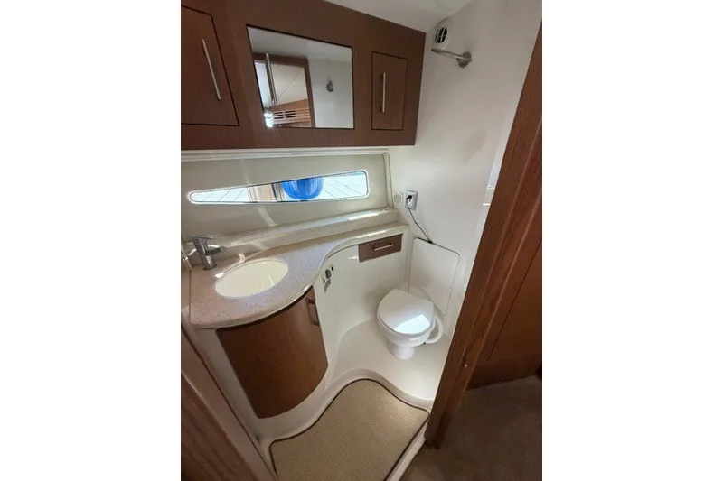 Slide: The Image of 2012 Carver 41 Cockpit Motor Yacht bathroom with modern fixtures and wood cabinetry. - 17