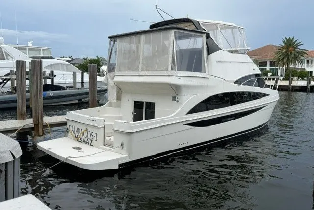 Slide: The Image of 2012 Carver 41 Cockpit Motor Yacht docked in a marina, side view. - 0