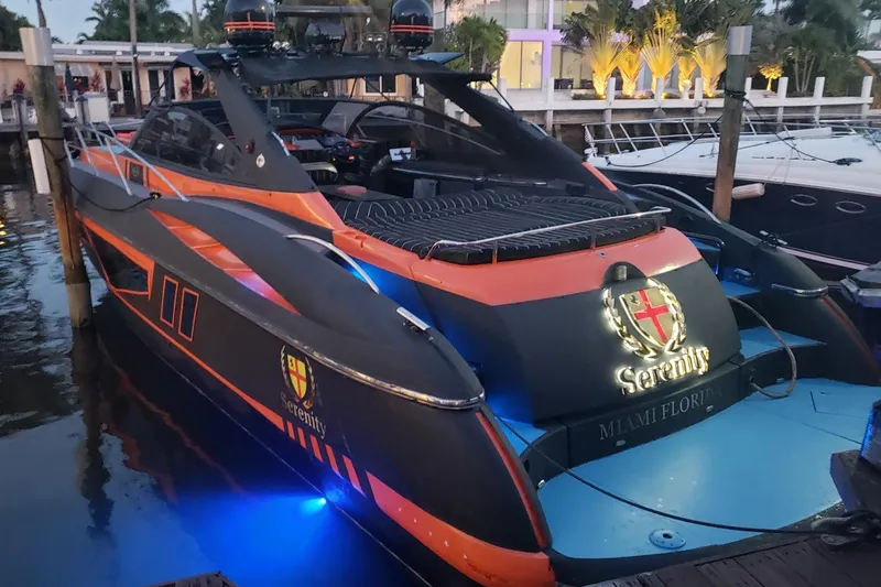 The Image of Sunseeker Camargue 50 yacht, 2000 model, docked with vibrant orange and black design. - 0