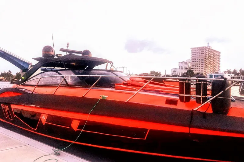 Slide: The Image of Red Sunseeker Camargue 50 yacht docked, 2000 model, with cityscape background. - 21