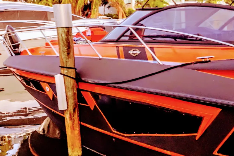 Slide: The Image of Sunseeker Camargue 50 yacht, 2000 model, docked with vibrant orange and black design. - 22