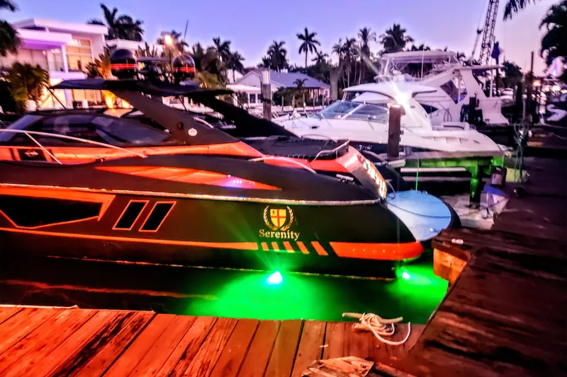 Slide: The Image of Sunseeker Camargue 50 yacht docked at sunset with vibrant green lights. - 9